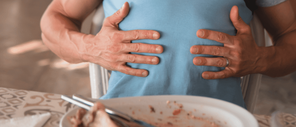 Hombre frotándose la tripa por un corte de digestión